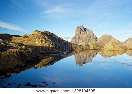 Midi Dossau Peak reflected in a lake. Ossau Valley, Pyrenees National Park, Pyrenees, France.