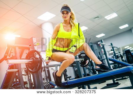 Gorgeous Blonde Woman Is Warming Up And Doing Workout At A Gym Looking At Camera.