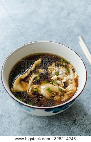 Asian Food Wonton Soup With Bok Choy And Chives In Porcelain Or Ceramic Bowl.