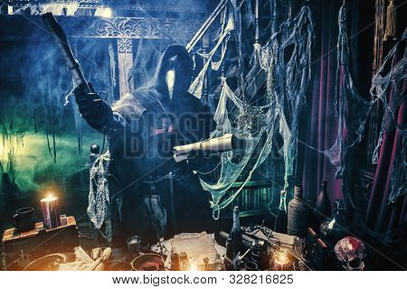 The plague doctor is working at his desk, inventing a cure for bubonic plague. The atmosphere of mysticism. Historical reenactment. Halloween. 