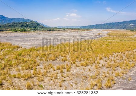 landscape of golden miscanthus with mountain and river under sky