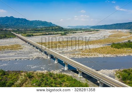 bridge over river with golden miscanthus under sky