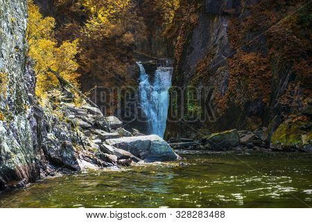 Korbu Waterfall at Lake Teletskoye in autumn Altai Mountains. The most famous lake waterfall