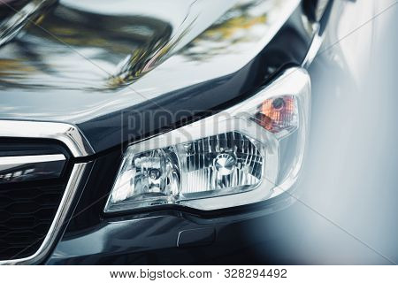 Selective Focus Of Headlamp And Capote Of Black Modern Car