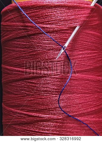 A Spool Of Cotton Thread With A Needle