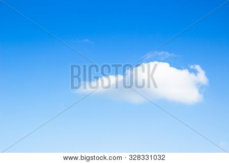 Blue Sky With Clouds Background. Beautiful White Fluffy Clouds On A Light Blue Sky Background. Clear