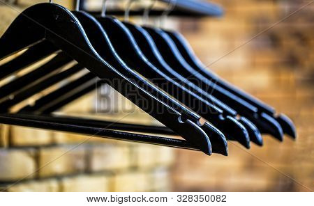 Wood Hangers Coat. Many Wooden Black Hangers On A Rod. Store Concept, Sale, Design, Empty Hangers. W