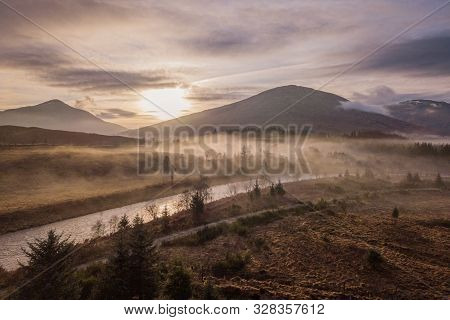 The Setting Sun Casting Shadows Across The Low Hanging Clouds On The River Orchy With The Scottish H