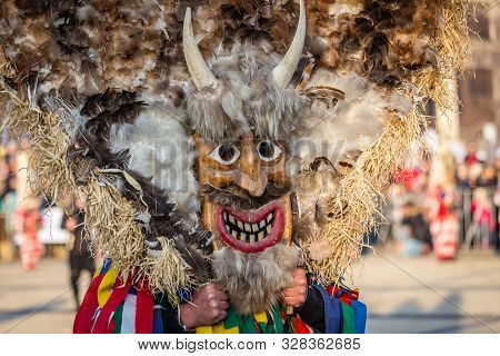 Mummers perform rituals to scare evil spirits at Surva festival at Pernik in Bulgaria. The people with the masks are called Kuker (kukeri). Mask made of wood feathers and horns.