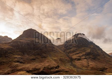 Two Of The Three Mountain Peaks Called The Three Sisters, Covered In Brown Wintery Vegetation On A P