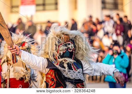 Mummers perform rituals to scare evil spirits at Surva festival at Pernik in Bulgaria. The people with the masks are called Kuker (kukeri). Wool mask and wood sword.