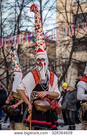 Mummers perform rituals to scare evil spirits at Surva festival at Pernik in Bulgaria. The people with the masks are called Kuker (kukeri). Mask with mustaches.