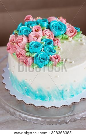 Gorgeous Cake Covered In Bright Roses Made Of Butter Cream Icing On Light Wooden Background