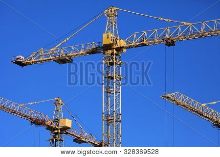 A Lot (bunch) Of Construction Cranes On The Blue Sky Background. Building Construction Site With Cra