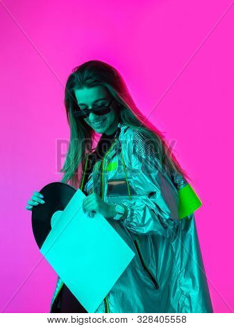 The Girl With The Vinyl Record. Colored Background And Neon Light. Modern Clothes. Music Poster. Ret