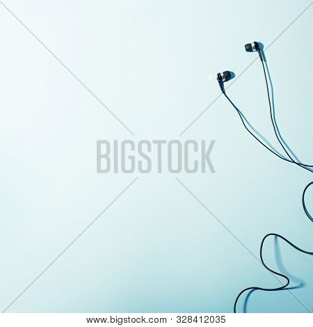 Headphones Of Different Types Flat Lay On Mint Color Background, Copy Space. Black In Ear Headphones
