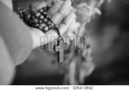 Hand Holding Rosary In Black And White Background. Senior Woman Holding Rosary With Open Hand With J