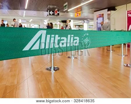 Fiumicino, Italy, July 2019: Green Ribbon Barrier With The Alitalia Airline Logo Inside The Leonardo