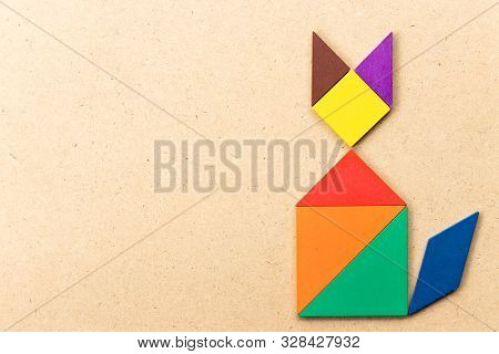 Color Tangram Puzzle In Sitting Cat Shape On Wood Background
