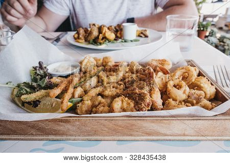 Frito Misto (varied Battered Deep Fried Seafood) Served On A Wooden Tray In A Restaurant, Selective 