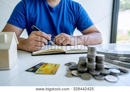 Man Writing Report To Planning Growing Saving To Strategy With Money Box For Future Plan Fund Of Tra