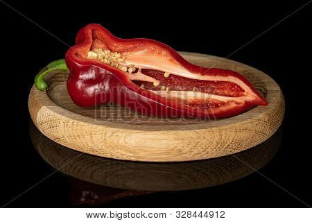 One Half Of Sweet Red Bell Pepper On Bamboo Plate Isolated On Black Glass