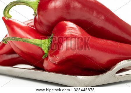 Group Of Four Whole Sweet Red Bell Pepper On Tray Isolated On White Background