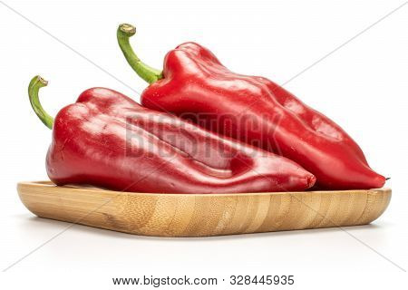 Group Of Two Whole Sweet Red Bell Pepper On Wooden Square Plate Isolated On White Background