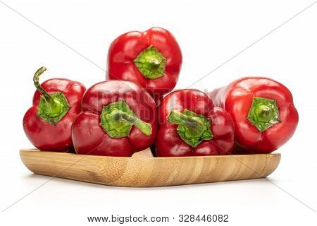 Group Of Five Whole Sweet Red Bell Pepper On Wooden Square Plate Isolated On White Background