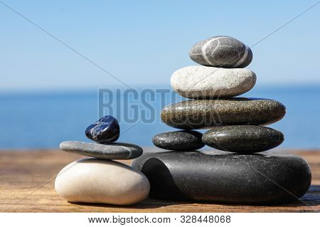 Stacks Of Stones On Wooden Pier Near Sea, Space For Text. Zen Concept
