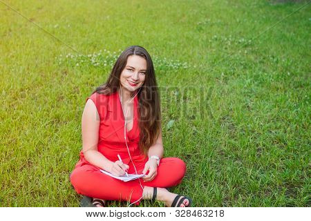 Portrait Of Young Smiling Business Woman In Red Suit In Earphones Listening To Music, Doing Online L