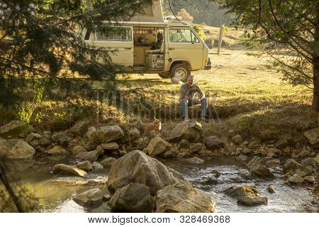 Encuentro Park, Chiapas, Mexico - April13th , 2018: Man Sit By The River With Dog And Camper Van