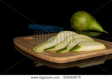 Group Of One Whole Five Slices Of Fresh Green Pear On Bamboo Cutting Board With Steel Knife Isolated