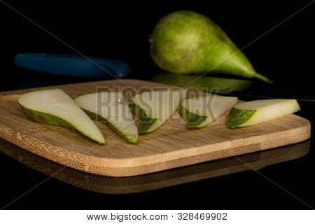 Group Of One Whole Five Slices Of Fresh Green Pear On Bamboo Cutting Board With Steel Knife Isolated
