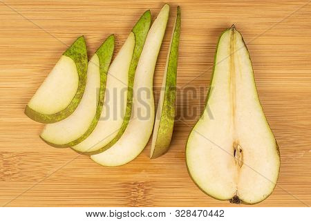 Group Of One Half Five Slices Of Fresh Green Pear Flatlay On Light Wood