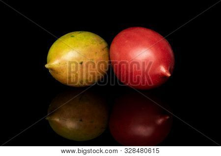 Group Of Two Whole Fresh Tomato De Barao Isolated On Black Glass