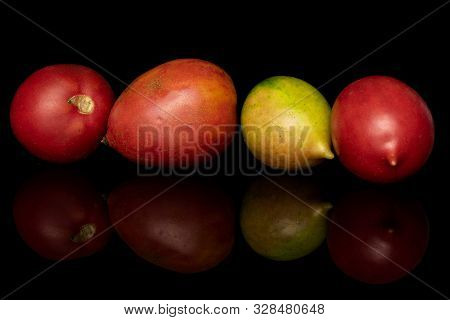 Group Of Four Whole Fresh Tomato De Barao Isolated On Black Glass