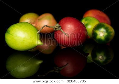 Group Of Seven Whole Fresh Tomato De Barao Isolated On Black Glass