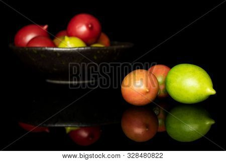 Group Of Ten Whole Fresh Tomato De Barao On Glazed Bowl Isolated On Black Glass