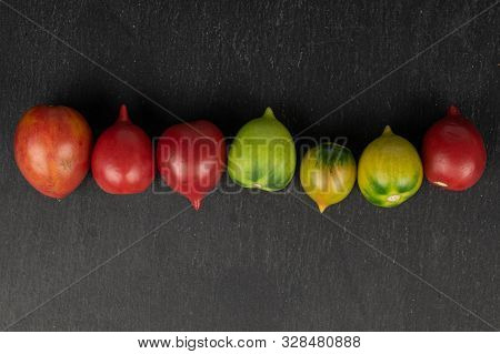 Group Of Seven Whole Fresh Tomato De Barao Flatlay On Grey Stone
