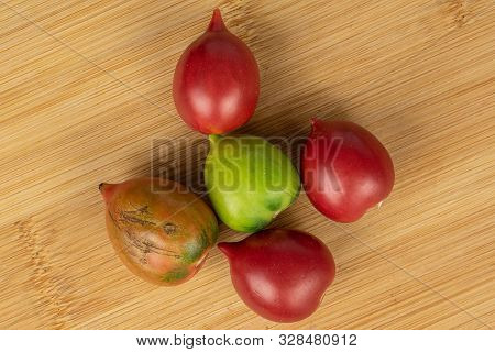 Group Of Five Whole Fresh Tomato De Barao Flatlay On Light Wood