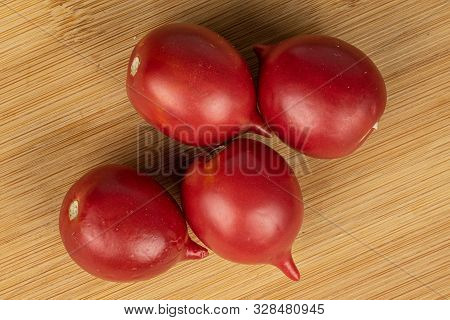 Group Of Four Whole Fresh Tomato De Barao Flatlay On Light Wood