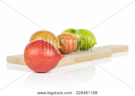 Group Of Five Whole Fresh Tomato De Barao On Wooden Cutting Board Isolated On White Background