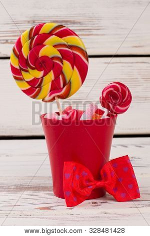 Miniature Red Pot Bucket With Lollipop And Candies. Flower Pot With Lollipops And Bow-tie Decoration
