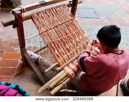 Cuenca, Ecuador - March 8, 2019: Ecuadorian Man Is Weaving Scarf Or Macana By Hand With Cotton Threa