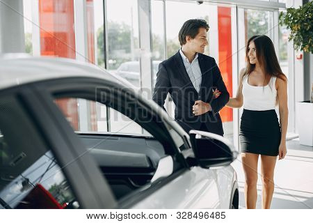 Stylish And Elegant Couple In A Car Salon