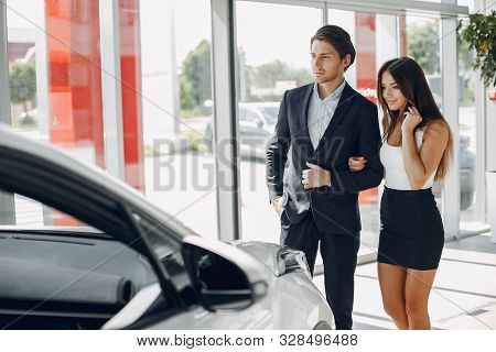 Stylish And Elegant Couple In A Car Salon