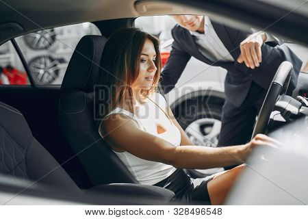 Stylish And Elegant Couple In A Car Salon