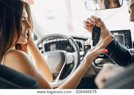 Stylish And Elegant Couple In A Car Salon