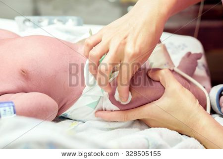 Image Of Nurse Hands Using Cotton Wool Swab With Alcohol To Clean The Baby's Leg Skin Before Vaccina